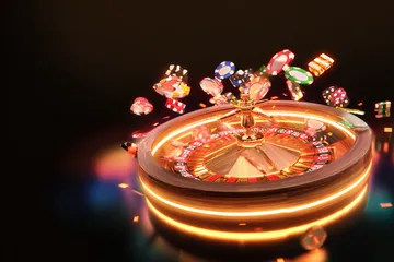 A glowing roulette wheel with cascading chips, symbolizing the engaging live and instant-win games available on K55GAME.